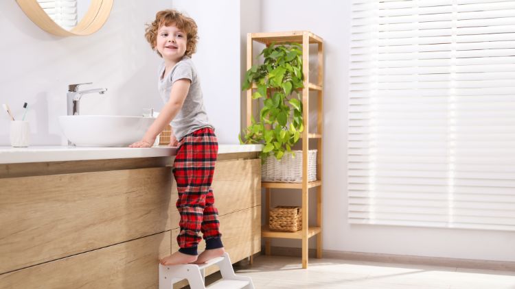 Little boy standing near bathroom vanity