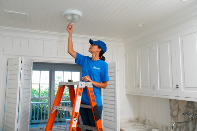 handyman working on light fixture
