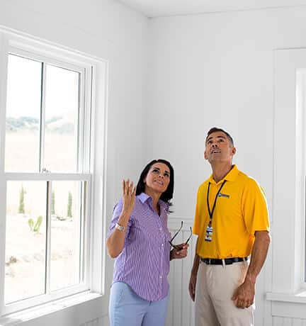 handyman from Handyman Connection inspecting interior wall 