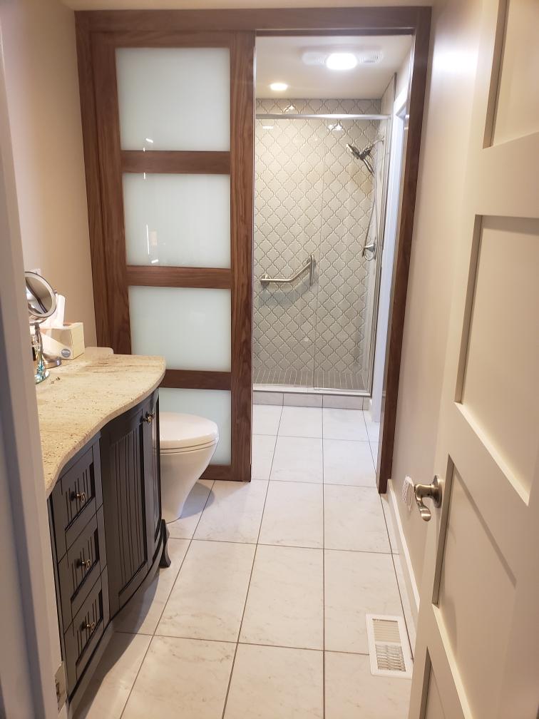 completed bathroom remodel with new tile flooring and plumbing fixtures installed