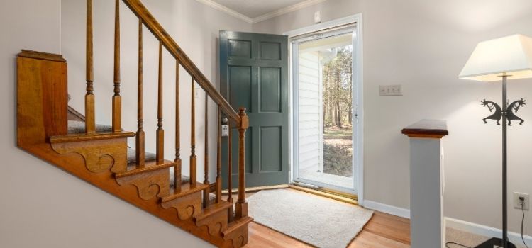 A Wooden Staircase In Front of an Entrance Door