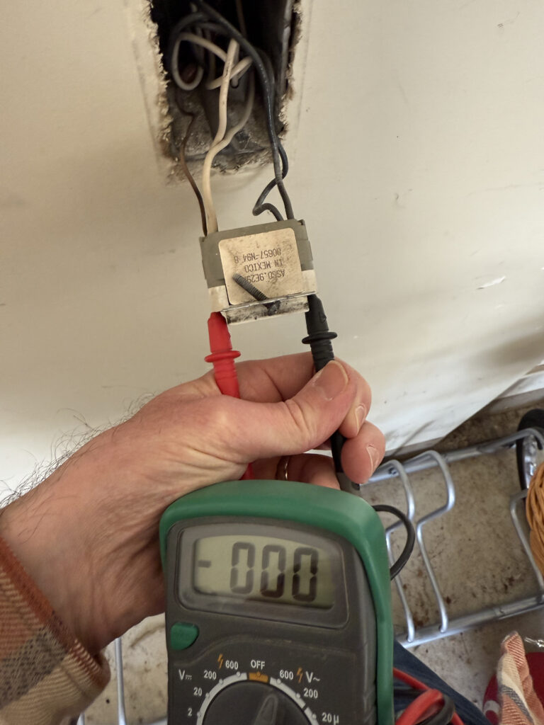 handyman testing electrical outlet in kitchen
