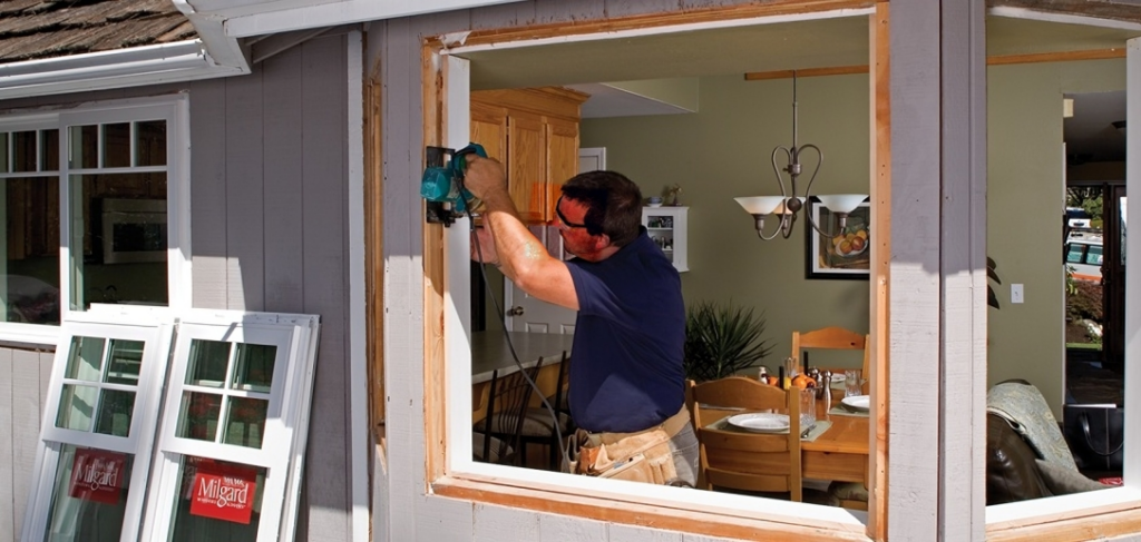 handyman installing new windows in a home 