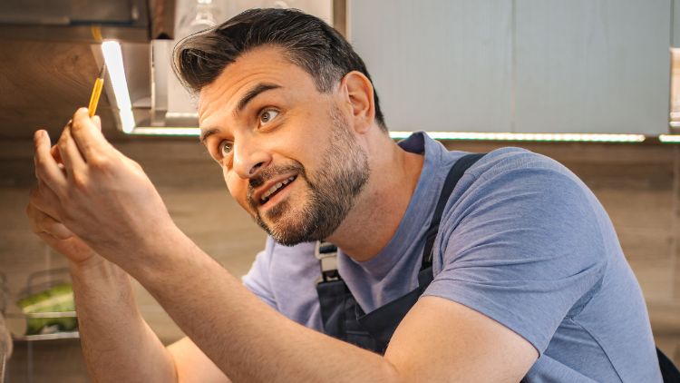 Handyman installing light under the cabinet