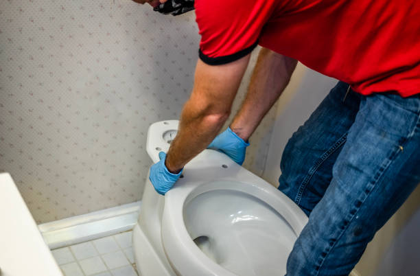 handyman installing a new toilet in a bathroom in Loves Park, IL