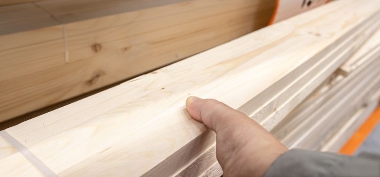 Construction worker choosing wooden plank in hardware store