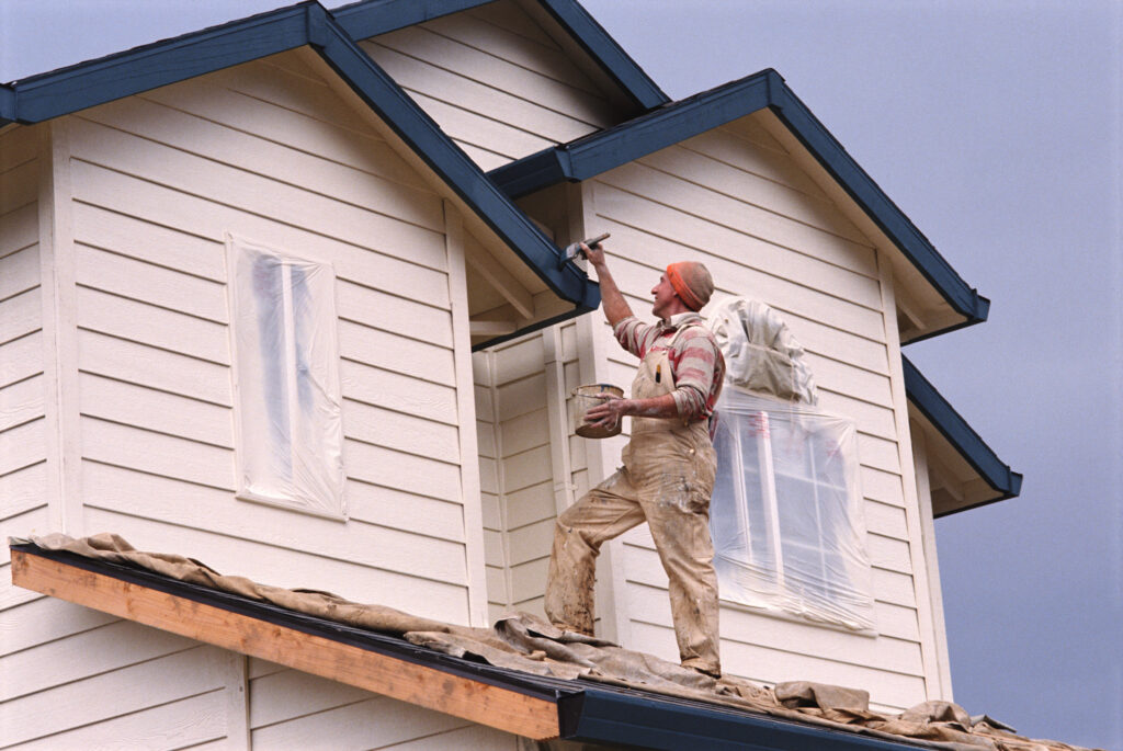 craftsman in Shawnee, KS, painting the outside of a house