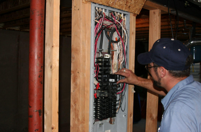electrical repair handyman from Handyman Connection repairing fuse box in Watkins, CO