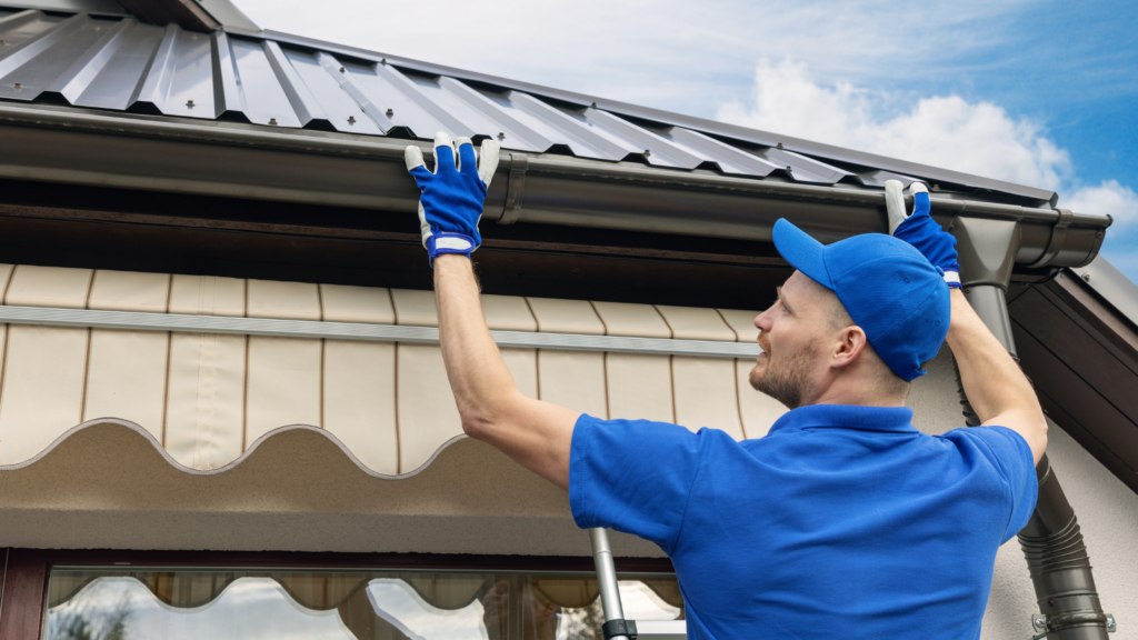 handyman doing gutter maintenance work outside home