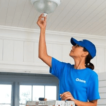 craftsperson installing electrical light fixture