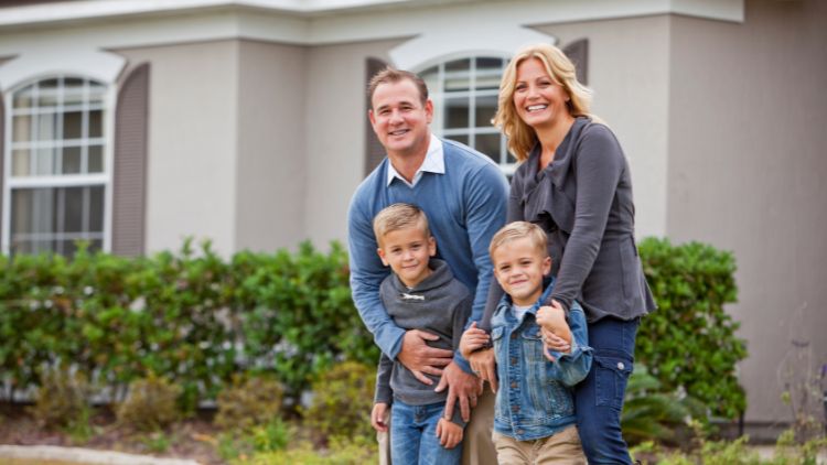 Family standing in front of house